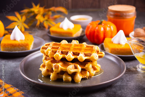Autumn homemade pumpkin spice waffles with honey topping.