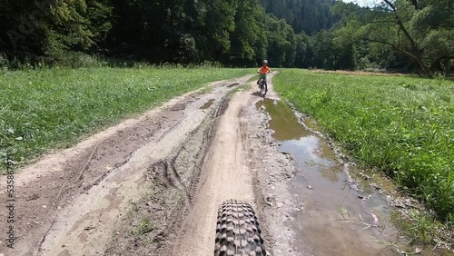 Cute little boy riding a bike.	 
Boy riding a bike along the cycle path. Stabilized video. 