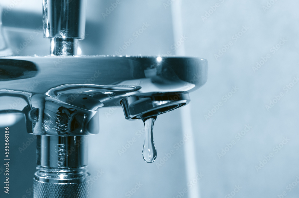 Chrome tap with falling water drop close up Chrome tap with falling water drop close up