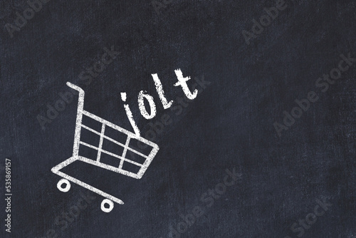 Chalk drawing of shopping cart and word jolt on black chalboard. Concept of globalization and mass consuming