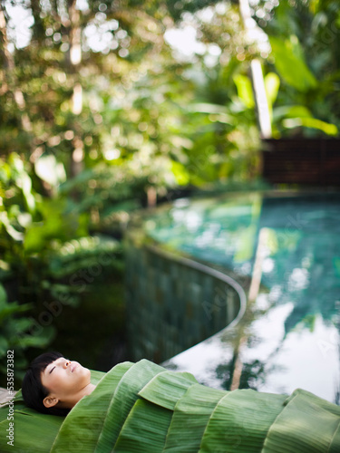 Woman wrapped in banana leaves at a Spa in Ubud, Bali, Indonesia.