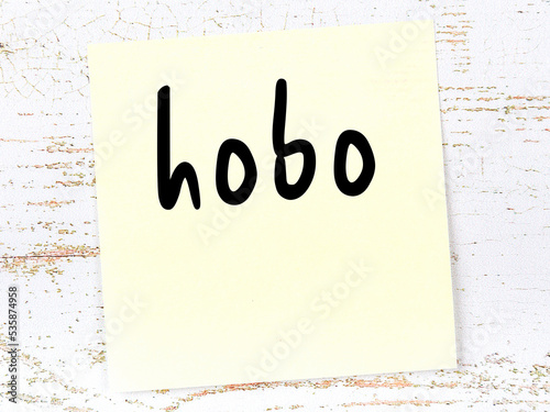 Fotografija Yellow sticky note on wooden wall with handwritten word hobo
