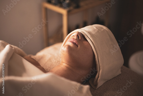 A young woman undergoes facial biotherapy in an aesthetic clinic.