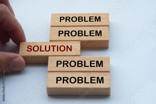 Hand putting wooden block with word solution in the middle of wooden blocks with words problem. Solution concept photo