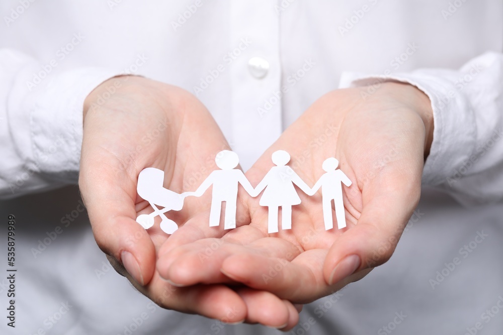 Woman holding paper family figures, closeup. Insurance concept Woman holding paper family figures, closeup. Insurance concept