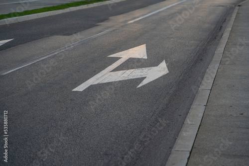 a close-up of a sign drawn on the road signifying a right turn or straight ahead. Tools for regulating traffic rules. Road signs.