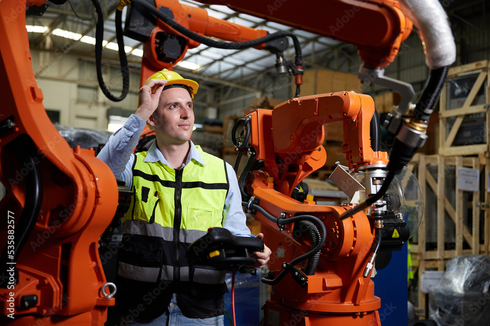 factory worker or engineer operating remote switch controller to control robot machine in the factory factory worker or engineer operating remote switch controller to control robot machine in the factory