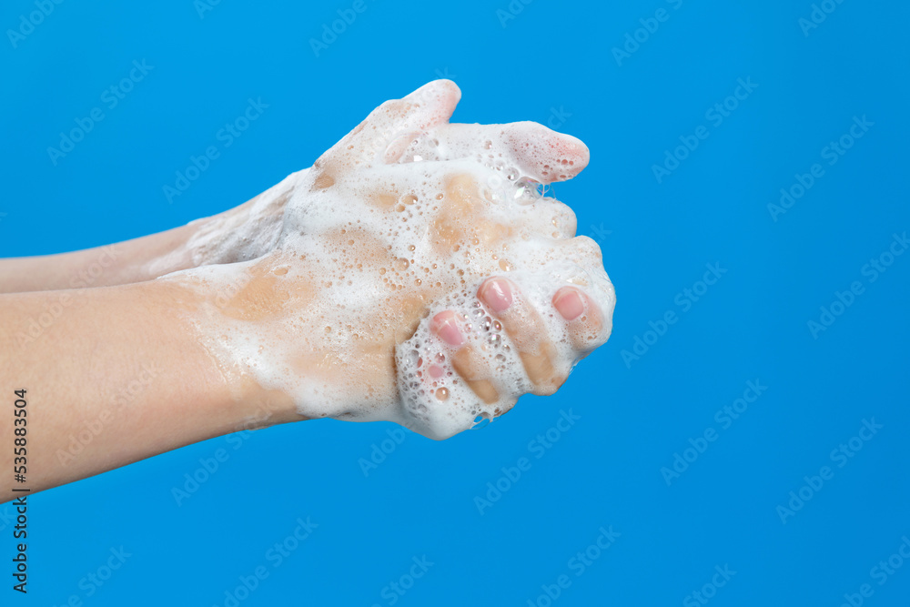 Woman washing nails on blue background Woman washing nails on blue background