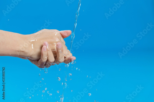 Fototapeta Naklejka Na Ścianę i Meble -  Washing hands with water on blue background