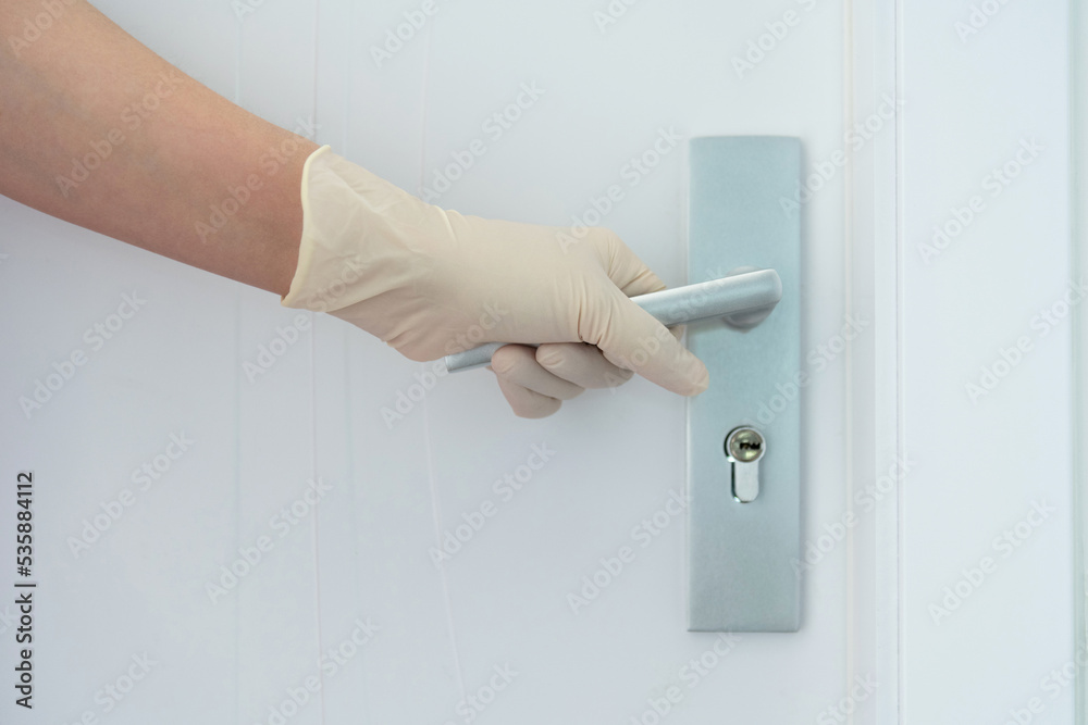Woman's hand open the door with glove Woman's hand open the door with glove
