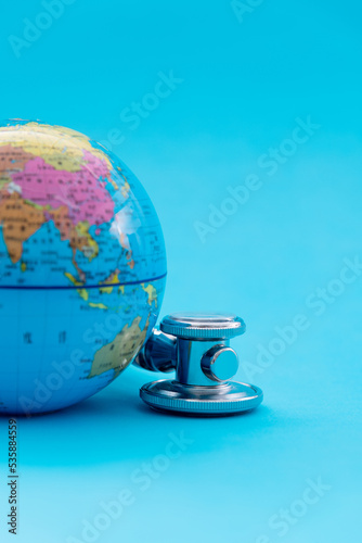 Globe with stethoscope on blue background