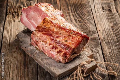 Delicious artisanal whole smoked slab bacon on a cutting block. Traditionally smoked meats on wooden board. Rustic style. banner menu recipe