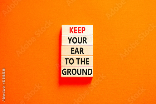 Keep your ear to the ground symbol. Concept words Keep your ear on the ground on wooden blocks. Beautiful orange table orange background. Business keep your ear on the ground concept. Copy space.