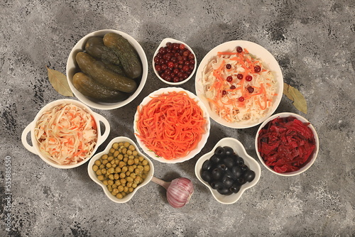 Fermented products on a concrete table, food background, advertising banner, healthy food concept, sauerkraut, kimchi, pickled beets, cucumbers, peas, olives, 