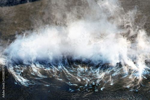 Dry ice evaporates on asphalt with lots of steam