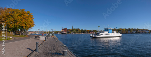 Photography A harbor commuting ferry arriving at the island Skeppsholmen a colorful sunny au