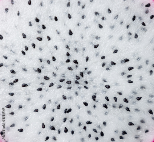 Fresh pulp dragon (pitaya or pitahaya) fruit textured background, white surface sweet with black seeds. Closeup or macro of texture detail dragonfruit