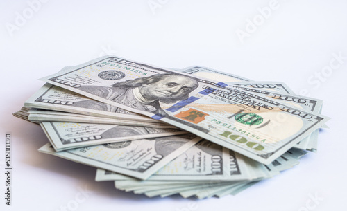 Pile of 100 dollar banknotes on white background