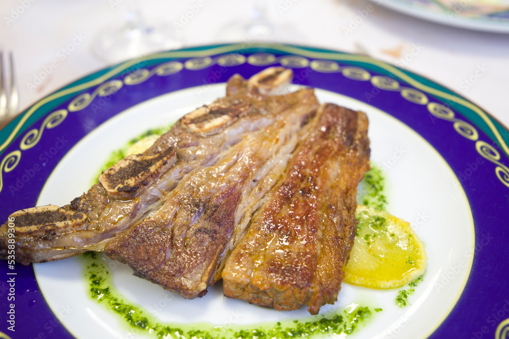Beef churrasco with garlic and parsley sauce on blue plate Spain Beef churrasco with garlic and parsley sauce on blue plate Spain
