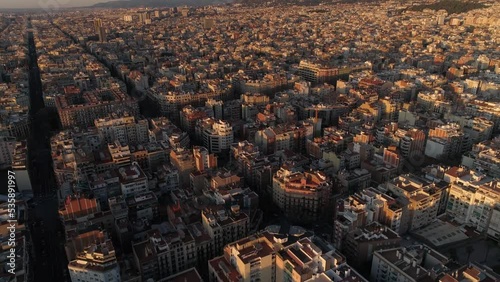 Aerial view of Barcelona city skyline and Sagrada Familia Cathedral at Sunset. Eixample residential famous urban grid. Cityscape with typical urban octagon blocks. Catalonia, Spain 4k Aerial View photo