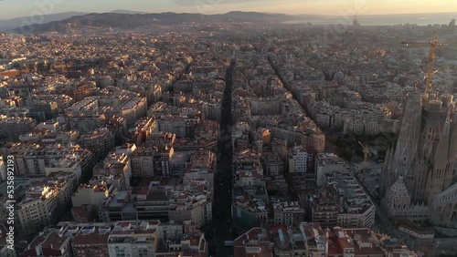 Aerial view of Barcelona city skyline and Sagrada Familia Cathedral at Sunset. Eixample residential famous urban grid. Cityscape with typical urban octagon blocks. Catalonia, Spain 4k Aerial View photo