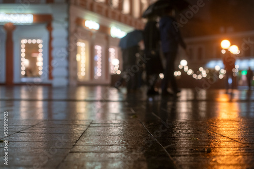 Night urban landscape, colored lights reflected in the wet asphalt in fall. Rainy night street in the city. The lights of a rainy night in the autumn city of disfocus and bokeh.