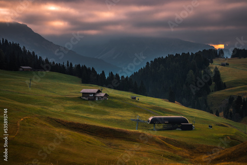 Cloudy sunrise in mountain meadow Seiser Alm in Dolomites