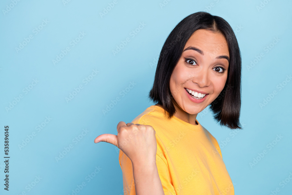 Photo of impressed ecstatic lovely girl with bob hairdo wear yellow t-shirt indicating empty space isolated on blue color background Photo of impressed ecstatic lovely girl with bob hairdo wear yellow t-shirt indicating empty space isolated on blue color background