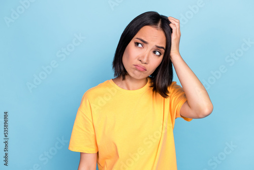Photo of young adorable pretty nice woman scratch head pouted lips unhappy look empty space information isolated on aquamarine color background