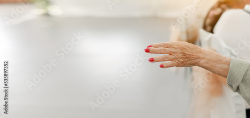 Elderly woman with red manicure, wrinkled hand palm with, clearly visible veins reaching out forward. Banner. Isolated white background, close up, copy space. Ageing process