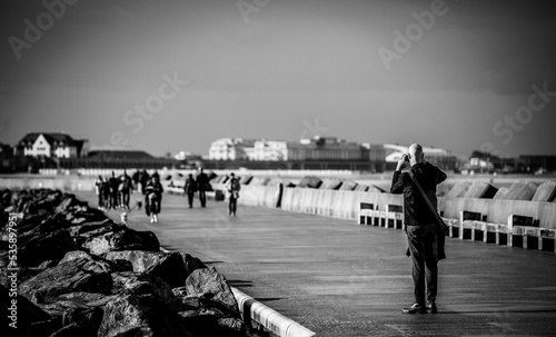 A man takes pictures of the pier