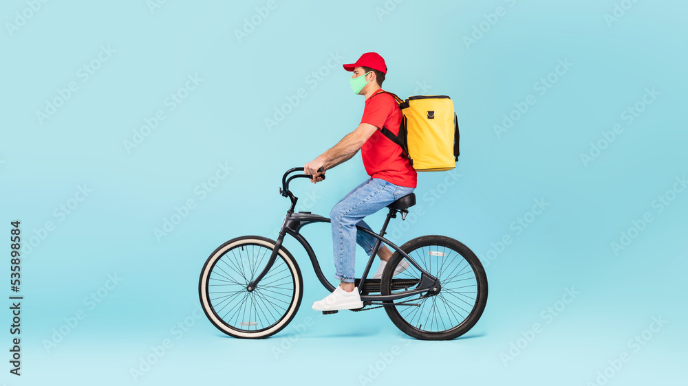 Guy With Yellow Backpack Delivering Food Riding Bike, Blue Background