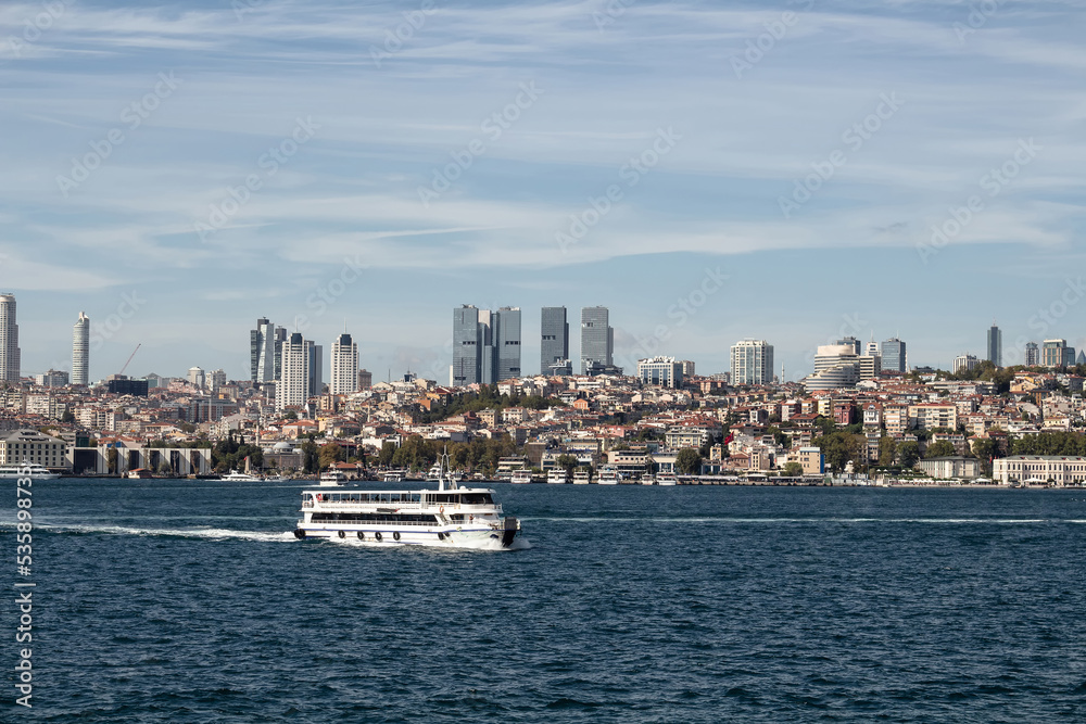 View of a cruise tour boat on Bosphorus and European side of Istanbul. It is a sunny summer day.