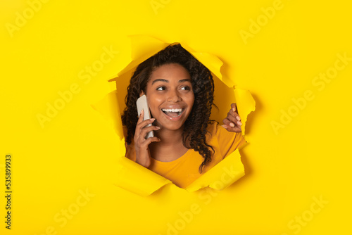 Black Lady Talking On Cellphone Posing In Hole In Paper © Prostock-studio