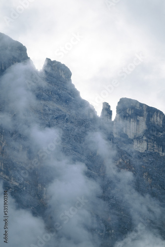 Amazing misty morning on the stunning Dolomite mountains in Italy. Pine forest with clouds and mist