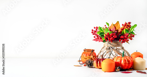 Autumn Still Life. Leaves, candles, pumpkins and more on a light background. The concept of autumn, coziness and warmth. Design with room for text.