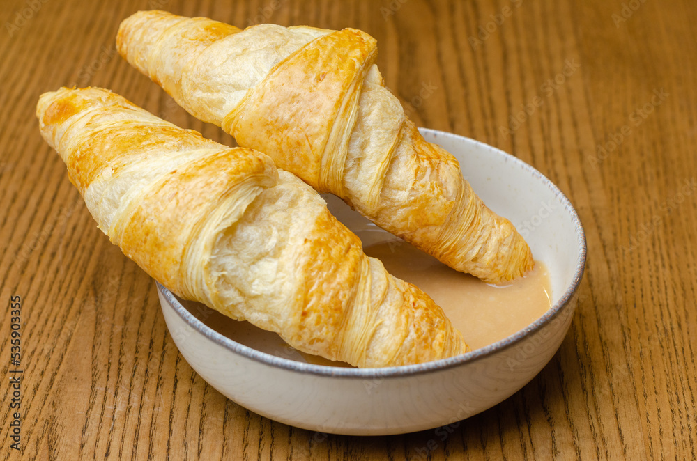 two croissants in condensed milk