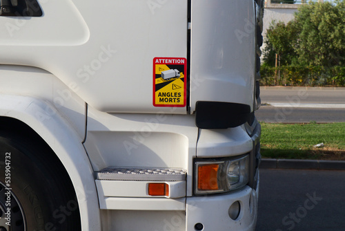 Sticker in a professional truck cabin indicating the existence of a blind spot in that area