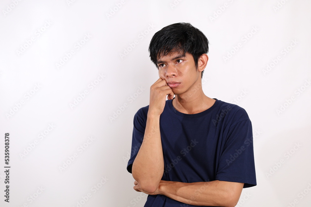 Sad asian young man standing while looking side. Isolated on white with copyspace Sad asian young man standing while looking side. Isolated on white with copyspace