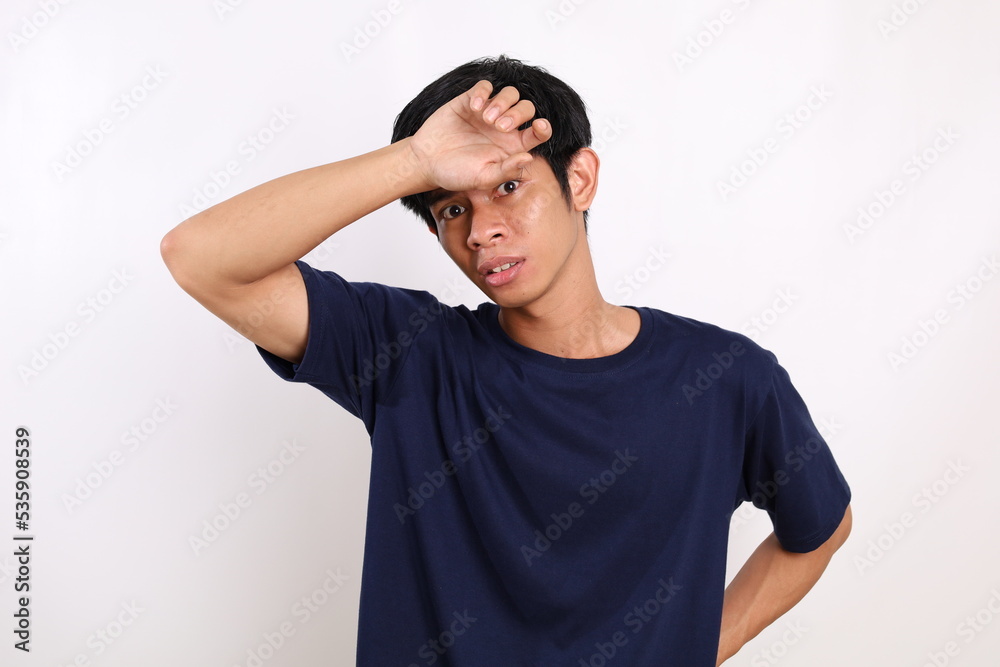 Scared asian young man standing while peeping through his hand. Isolated on white background Scared asian young man standing while peeping through his hand. Isolated on white background
