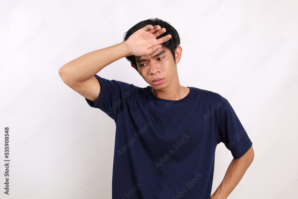 Asian young man standing with tired gesture and feeling hot. Isolated on white background Asian young man standing with tired gesture and feeling hot. Isolated on white background