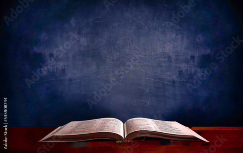 Open old book on wooden table.