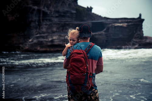 Father hugging his small daughter and looking with hope into the distance 