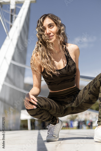 Foto full body of slim woman with long curly hair, sporty fashion with lycra top with