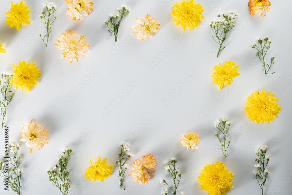 chrysanthemum and cutter flowers composition. Pattern and Frame made of various yellow or orange flowers and green leaves on white background. Flat lay, top view, copy space, spring, summer concept. chrysanthemum and cutter flowers composition. Pattern and Frame made of various yellow or orange flowers and green leaves on white background. Flat lay, top view, copy space, spring, summer concept.