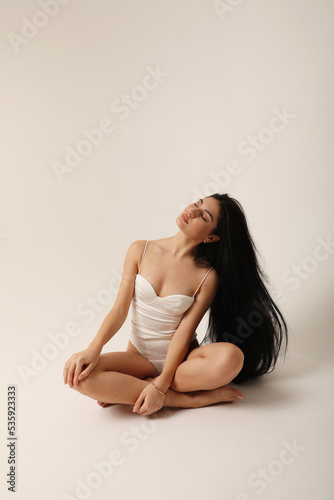 Beautiful young woman with long dark hair. Hair and skin care. Vertical.