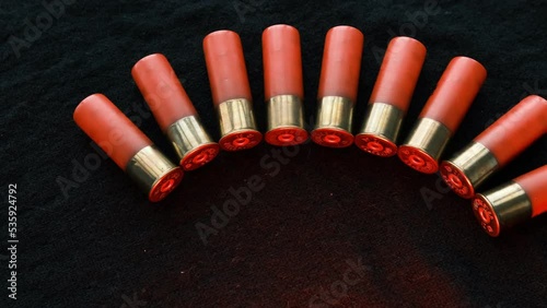 Red Shotgun shells on a black surface. Ammunition for 12 gauge smoothbore weapons. Hunting ammunition. Dark background