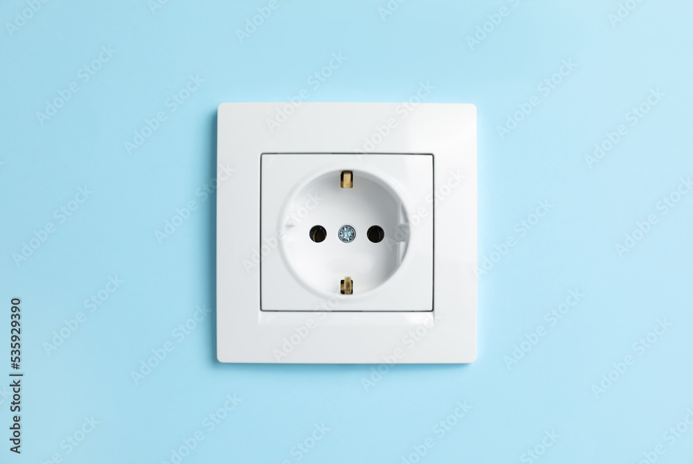 Power socket on light blue wall. Electrical supply