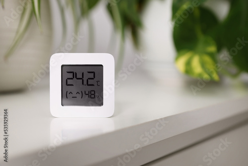 Digital hygrometer with thermometer on white table, space for text