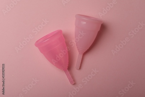 Menstrual cups on pink background, top view photo